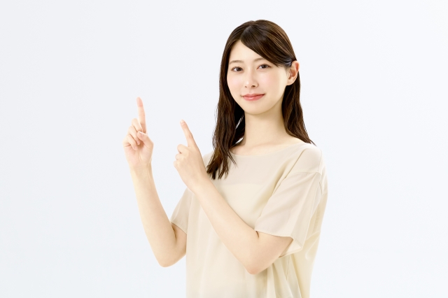 両手で指差しする若い女性