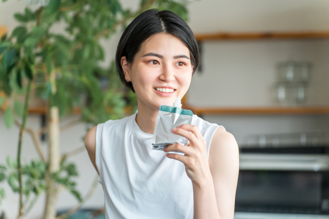 ゼリー飲料で栄養補給する若いアジア人女性