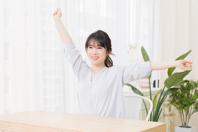 部屋で深呼吸をする若い女性