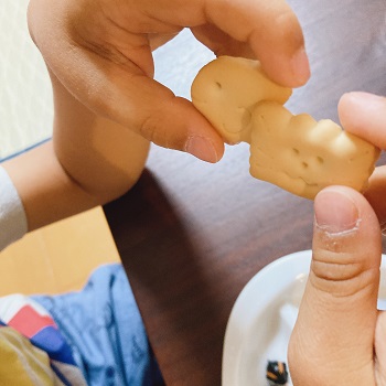 かにビスを持つ子どもの手