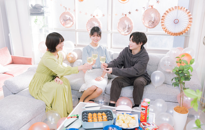 ホームパーティーでシャンパンを持って乾杯する男女