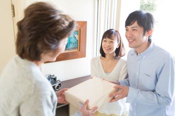 菓子折りを渡す夫婦