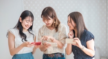 友人とSNSを確認するイメージ